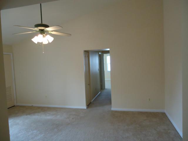Living Room With Ceiling Fan And A Vaulted Ceiling